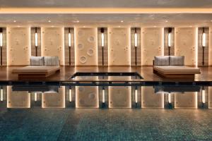 达兰萨拉Hyatt Regency Dharamshala Resort的大型客房设有两张沙发和一个游泳池