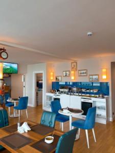 巴统Batumi Next Sea Aparthotel的一间带蓝色椅子的客厅和一间厨房