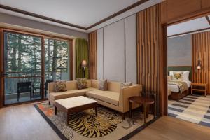 达兰萨拉Hyatt Regency Dharamshala Resort的客厅配有沙发和1张床