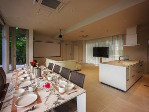 白滨Shingetsuann Shirahama的用餐室配有长桌和餐具