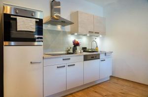 韦莱姆Alpok-Spirit Apartment – Velem的厨房配有白色橱柜和水槽