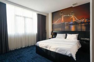 胡志明市DAISY HOTEL的酒店客房设有一张床,墙上挂着一幅大画