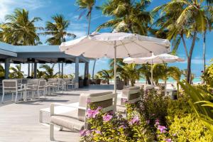 妮兰朵南环礁Riu Palace Maldivas- All Inclusive的海滩上带椅子和遮阳伞的庭院