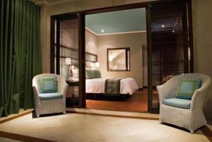 乌布Cinta inn的一间卧室配有一张床、两把椅子和镜子