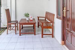 日惹OYO 91803 Gita Graha Guest House Syariah的庭院配有两把椅子、一张桌子和一张桌子以及椅子。