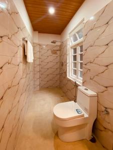 甘托克THE APARTMENT的一间带白色卫生间的浴室和窗户。