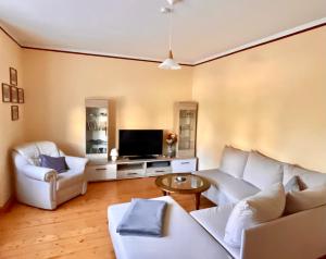拉德博伊尔Ferienhaus Mühlberg的客厅配有2张白色沙发和电视