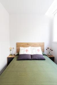 格拉纳达La Habitación del Arquitecto的一间卧室配有带两个枕头的绿色床