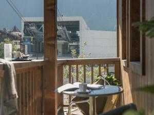 迈尔霍芬Apart Central – Premium Mountain&Garden的阳台配有桌子和咖啡