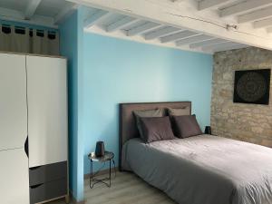 Cazes-MondenardLa Caza du quercy的一间卧室设有一张床和蓝色的墙壁
