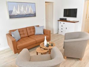 奥斯赛拜-塞林Villa Freya - Apt. 01的客厅配有沙发、两把椅子和电视