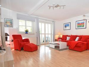 奥斯赛拜-塞林Villa Freya - Apt. 06的客厅配有红色的沙发和两把椅子
