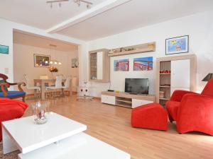奥斯赛拜-塞林Villa Freya - Apt. 06的客厅配有红色椅子和电视