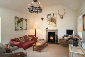 Riverside Cottage, Bridge of Balgie, Glenlyon, Perthshire的客厅设有红色的沙发和壁炉