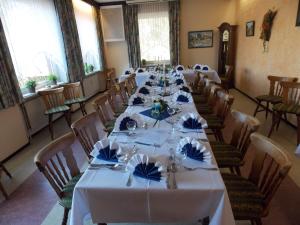 朗灵恩兰德盖斯特豪弗艾尔乐帕蒂尔斯酒店的一间长餐厅,配有白色的桌子和椅子