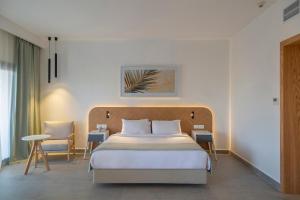 沙姆沙伊赫Amphoras Beach的卧室配有一张床和一张桌子及椅子