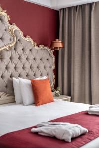 利沃夫Grand Hotel Lviv Casino & Spa的卧室配有一张带橙色枕头的大型白色床。