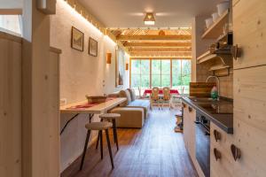 博希尼ALPIK Chalets - Bohinj的厨房以及带沙发和桌子的客厅。