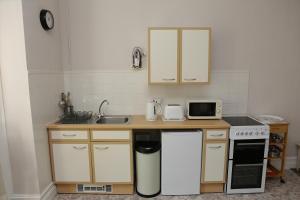 托基Abbey View Holiday Flats的厨房配有水槽和带微波炉的台面。