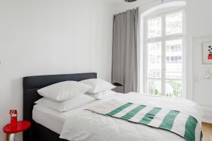 柏林Luxury 2 Bedroom apartment in the heart of Mitte, Berlin的白色的床、绿色和白色枕头以及窗户