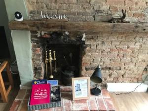 克莱尔Almond Cottage Clare - 2 bedroom English Cottage的砖砌壁炉,上面有标志,欢迎客人