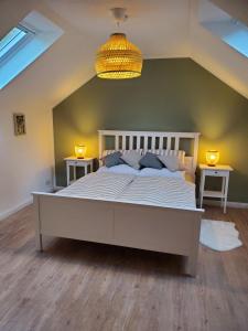 索尔陶Familienfreundliche Ferienwohnung Soltau的卧室配有一张带两张桌子的大型白色床