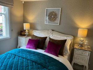 约克铜门公寓的卧室配有蓝色和白色的床和紫色枕头