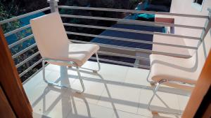 达累斯萨拉姆Hotel Amaranth的阳台上配有两把白色椅子