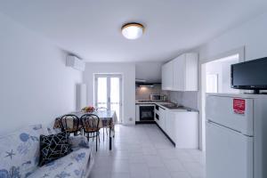 圣贝内代托-德尔特龙托Residence Dolcemare的厨房以及带沙发和桌子的客厅。