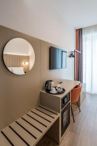 米兰BB Hotels Smarthotel Duomo的酒店客房设有一张桌子和一面镜子