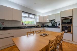 爱丁堡Craigey Beach Home的一个带木桌和椅子的大厨房
