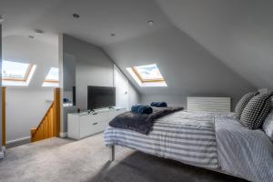 爱丁堡Craigey Beach Home的一间卧室设有一张床、一台电视和天窗。