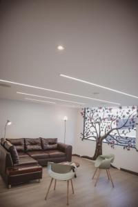 马尼萨莱斯Apartahotel La Arboleda HC的客厅配有沙发和树壁画