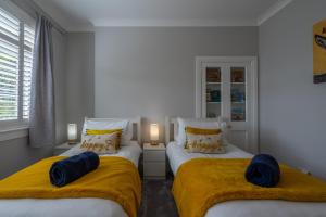 爱丁堡Craigey Beach Home的一间卧室配有两张带黄色毯子的床