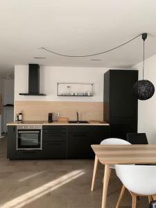 ErmatingenStudio Apartment am Bodensee - modern und stilvoll的厨房配有黑色家电和木桌