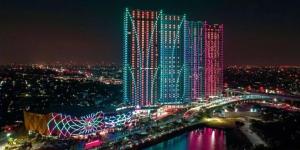 贝克西Grand Kamala Lagoon by 21 Room Netflix的一座有灯的建筑,晚上有桥