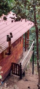El PacíficoCabaña en el Bosque de San José del Pacifico 2的屋顶建筑前的木凳