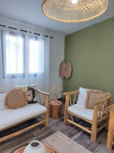 萨拉济Villa Couleur Nature的客厅配有两把椅子和吊灯