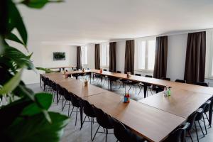 希尔德斯海姆Schlafladen Hildesheim Hotel & Hostel的一间会议室,配有长桌子和椅子