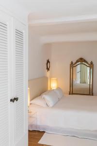 维琪奥港Grand Hôtel De Cala Rossa & Spa Nucca的卧室配有白色的床和镜子