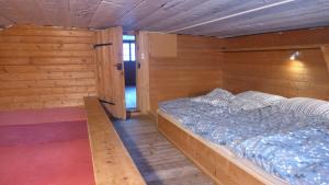 阿德尔博登哈密度假屋的木制客房内的一间卧室,配有一张床