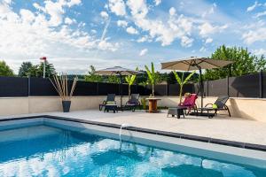 Bon-EncontreVilla des Oliviers : Sublime villa avec piscine chauffée et privée, terrasse de 185m²的游泳池旁设有椅子和遮阳伞