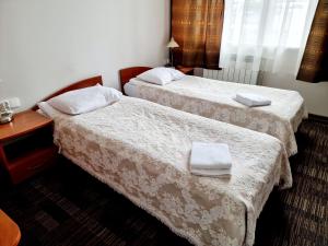 华沙Noclegi Stadion Bed & Breakfast的两张位于酒店客房的床,配有毛巾