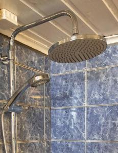 腓特烈斯塔Large, quiet and centrally located apartment的浴室铺有蓝色瓷砖,配有淋浴头