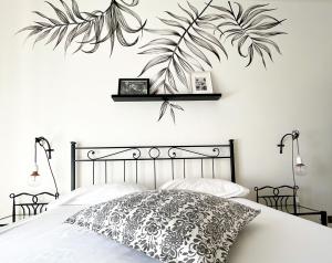 罗马优福诺维荫友好公寓的卧室配有一张黑色和白色的床,墙上挂着植物
