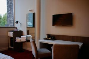 OverpeltHotel De Boskar Pelt的酒店客房配有书桌和椅子