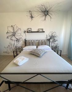 罗马优福诺维荫友好公寓的卧室内的一张床铺,墙上挂着鲜花