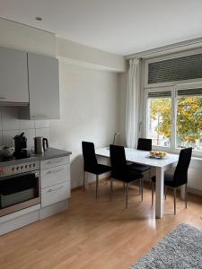 圣加仑over-night City-Flat的厨房配有白色的桌椅和窗户。