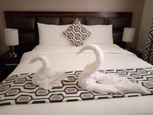 安曼沙姆斯艾尔韦布德公寓式酒店的两个白天鹅坐在床上