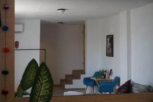 蒙特雷Hospedaje con vista a la ciudad的客厅设有楼梯、桌子和蓝色椅子